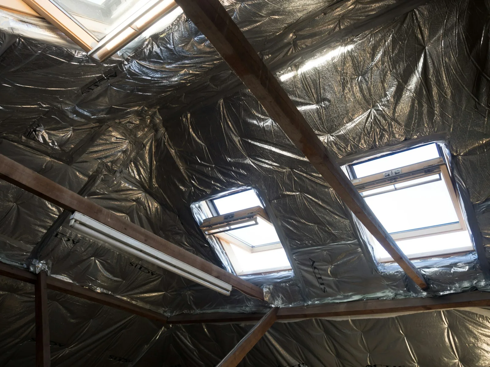 Blown-in attic insulation under skylights